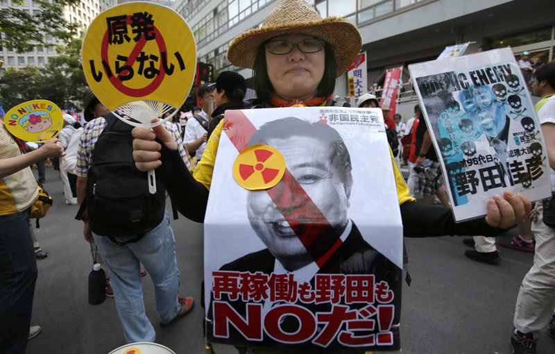 A protester holds a placard that reads, “No to the restart of the nuclear reactors and Prime Minister Noda” in a march in Tokyo on July 29.