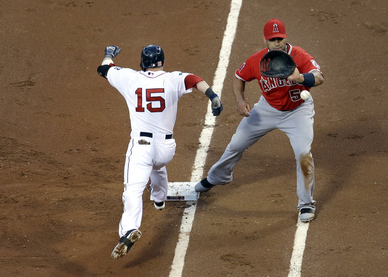 Dustin Pedroia of the Boston Red Sox is safe at first on a dropped third strike as first baseman Albert Pujols of the Los Angeles Angels gathers in the throw. The Angels won, 7-3.
