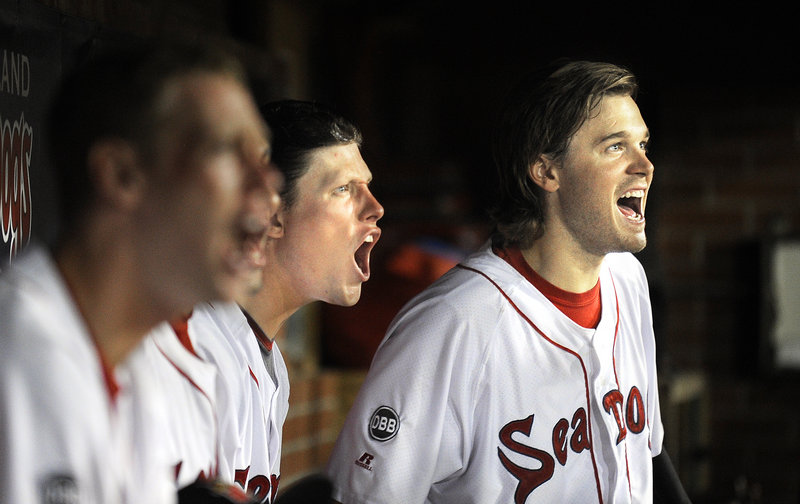 Peter Hissey, right, leads the cheers from the dugout Thursday night as the Portland Sea Dogs won again, moving within two games of .500 after a 36-54 record in early July.