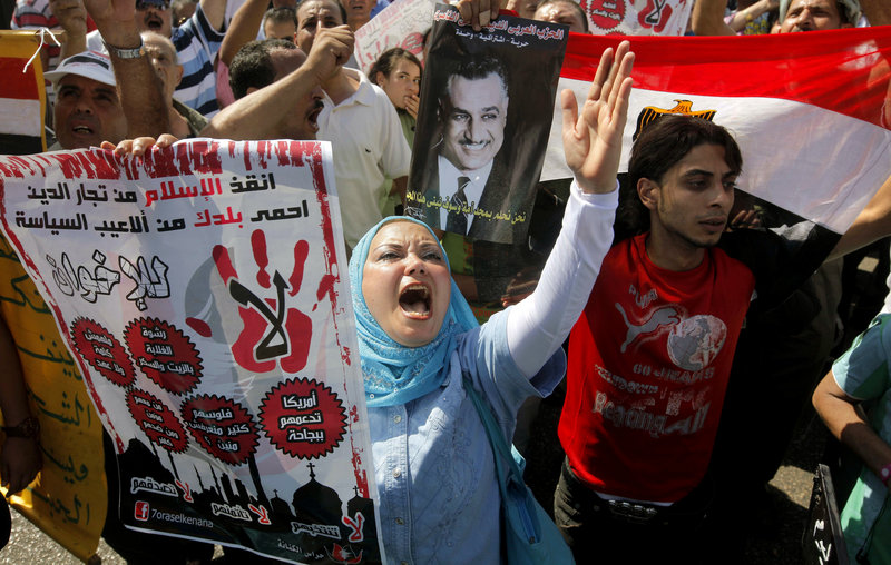 Anti-Muslim Brotherhood protesters hold posters of the late President Gamal Abdel Nasser in Cairo, Egypt, on Friday.