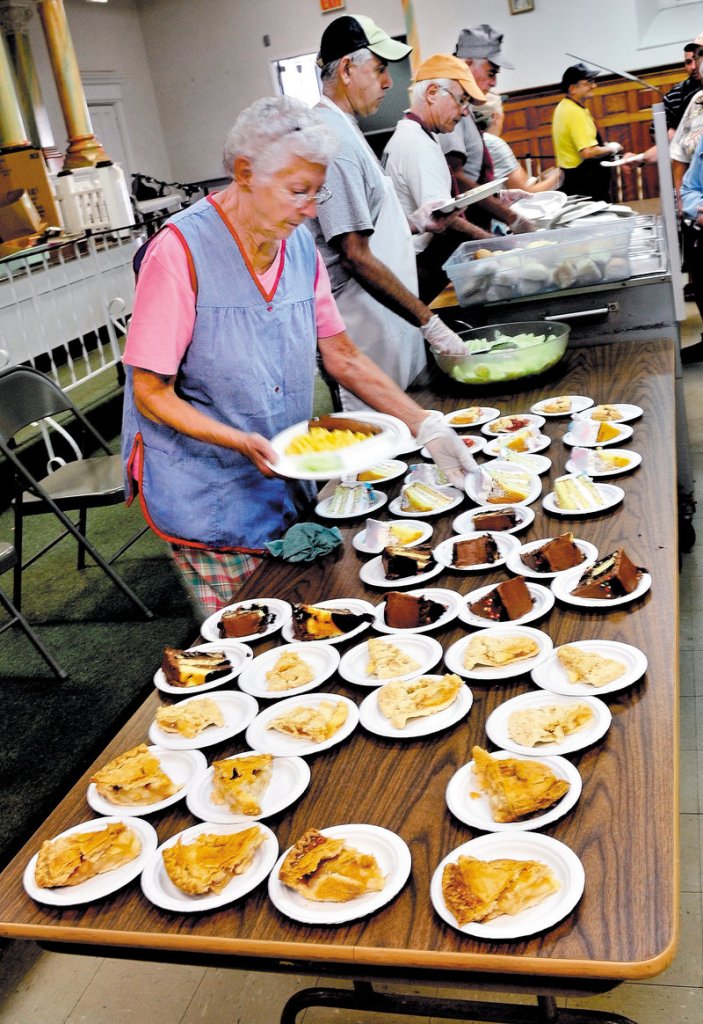 Patricia Stewart and other volunteers serve lunch at the Sacred Heart Soup Kitchen in Waterville on Monday.