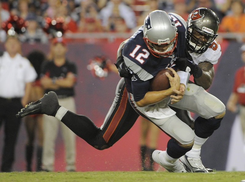 New England’s Tom Brady is sacked by Tampa Bay’s Adam Hayward during first-half action of their NFL preseason football game Friday night in Tampa, Fla. Brady threw one touchdown and had one interception in three quarters.