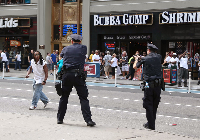 Police and a man wielding an 11-inch knife confront each other in New York’s Times Square on Aug. 11. The man, identified as Darrius Kennedy of Hempstead, N.Y., a native of South Carolina, was shot dead by police a few blocks farther downtown.