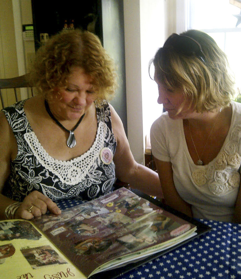 Magi Bish, left, looks at a scrapbook of remembrances of her slain daughter, Molly Bish, with Molly’s older sister, Heather. State police spent two days last month questioning a Florida inmate in Molly’s death. Investigators have sent evidence for a new round of DNA testing, and prosecutors plan to ask the FBI’s behavioral analysis unit to review the 2000 case.