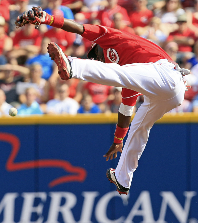 Cincinnati’s Brandon Phillips makes a high-flying but unsuccessful leap at a hit by the Cardinals’ Skip Schumaker during the Reds’ 8-2 win Saturday at Cincinnati.