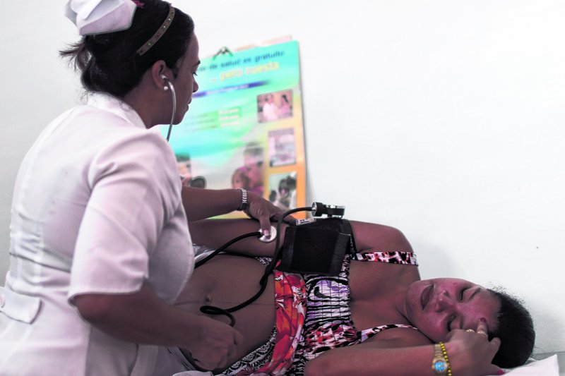 A nurse checks the blood pressure of patient Niurka Rodriguez, who is eight months pregnant, at a government-run neighborhood clinic in Havana, Cuba. Cuba’s system of free medical care, long considered a birthright by its citizens, is not immune to cutbacks under Raul Castro’s drive for efficiency.