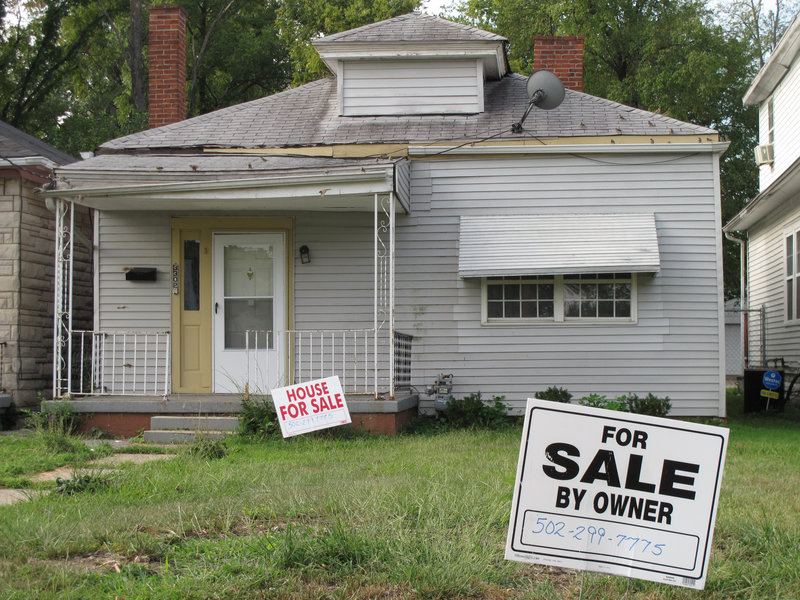 For-sale signs dot the front lawn of Muhammad Ali’s boyhood home Monday in Louisville, Ky.