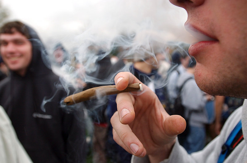 A University of Colorado student joins a crowd smoking marijuana during a 2005 pro-pot gathering at the university. People who started using marijuana before age 18 risk losing some of their IQ by the time they’re 38, a study says.