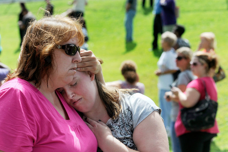 Tracie Bradford of Perry Hall, Md., consoles her daughter Leah, a student at Perry Hall High School who said she was in the school’s cafeteria when a student was shot there and critically wounded on the first day of classes Monday.