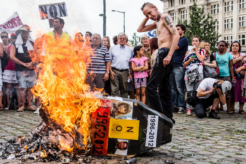 Demonstrators gather around a burning mock coffin with the pictures of Belgian child killer Marc Dutroux and his ex-wife, Michelle Martin, during a march this month in Brussels to remember their victims.
