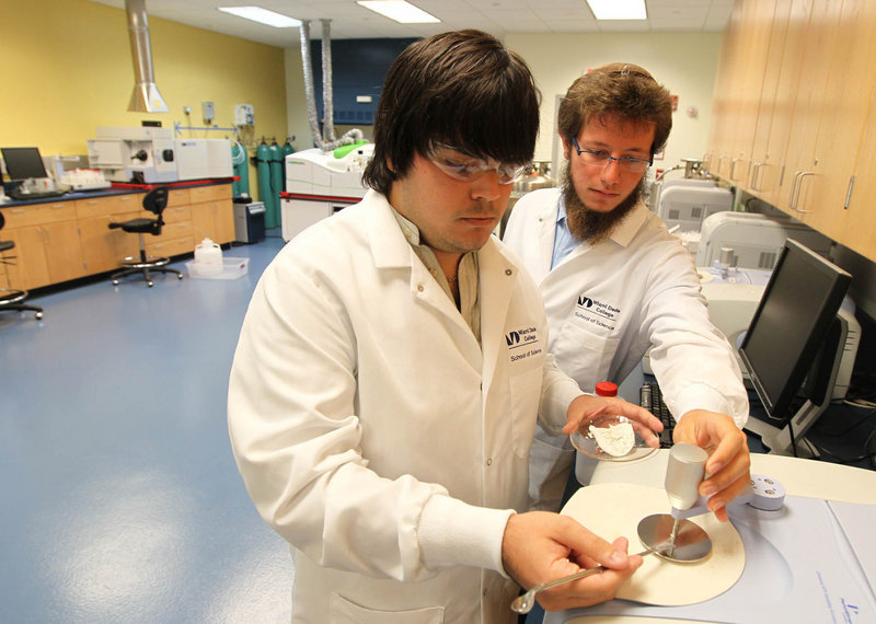 Gabriel Pacareu and Benjamin Eisenman work with an infrared spectrometer in a lab at Miami-Dade College’s School of Science, where classes focus on skills students can use in the medical industry.