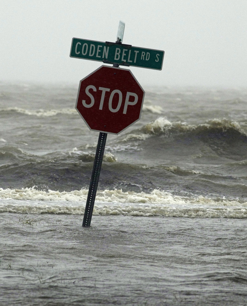 Waters of the Mississippi Sound surround a traffic sign along Coden Belt Road in Coden, Ala.