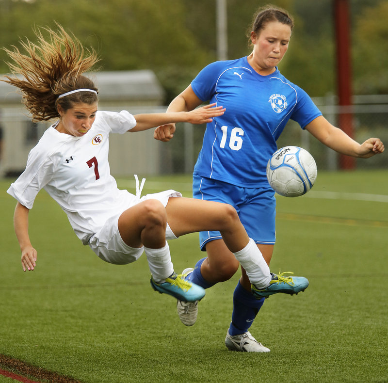 Kathryn Clark, left, of Cape Elizabeth lunges to get to the ball ahead of Falmouth’s Bri DiPhilippo.