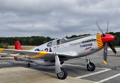 In this Saturday, September 24, 2011 photo at the Biddeford airport, Jim Sheppard, 87, of South Portland, one of the last remaining Tuskegee Airman, gets a chance to ride in a Tuskegee Airman Redtail P-51 Mustang, a plane just like he last flew during combat in 1945. A traveling exhibit dedicated to telling the story behind the obstacles that black military pilots and their ground support crews had to overcome to fight in World War II is coming to Brunswick next week.