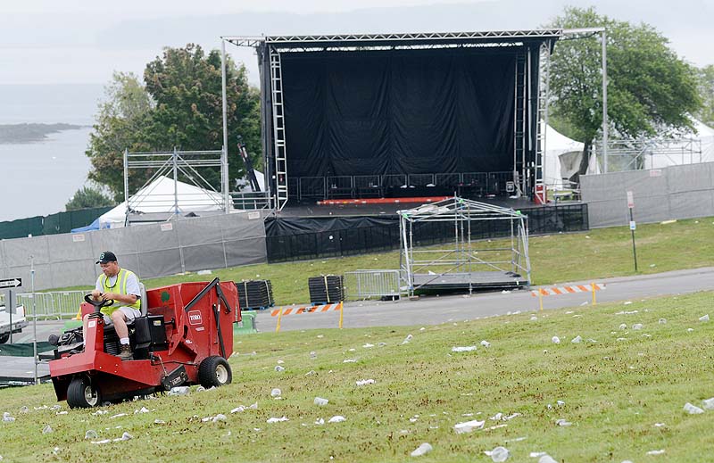 Robert Fogg of Portland Public Services Department cleans up trash with a turf sweeper on the hill at Eastern Prom Sunday. Fogg was one of many workers cleaning up following Saturday's Mumford & Sons concert.