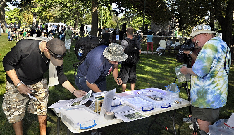 Visitors to the Atlantic CannaFEST at Deering Oaks on Saturday listened to music, speakers and promotions of medical marijuana. Here, visitors look at a calendar filled with photos of marijuana and information and sign a petition concerning medical marijuana at a table run by Medical Marijuana Caregivers of Maine. Roger Leisner, right, collects money for buttons and calendar sales to support the effort. Leisner was one of four 2012 winners of Maine Cannabis Awards. He ran the table with Hillary Lister.