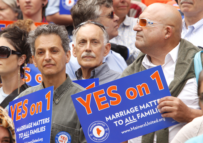 Dominic Rizzo, Nick McKenney and William Church, left to right, listen to a speaker on Monday during a rally at Portland City Hall held by Mainers United for Marriage.