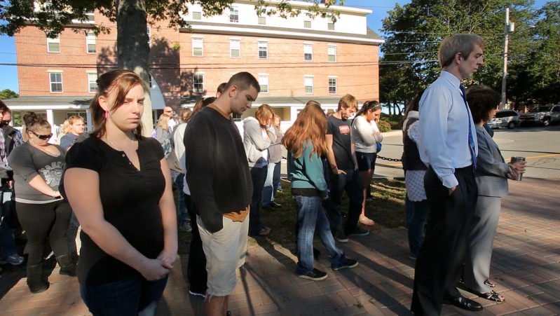In memory of the Sept. 11, 2001, terrorist attacks, freshman Alli Buck, left, stands with other students and staff during a moment of silence at Southern Maine Community College in South Portland on Tuesday.
