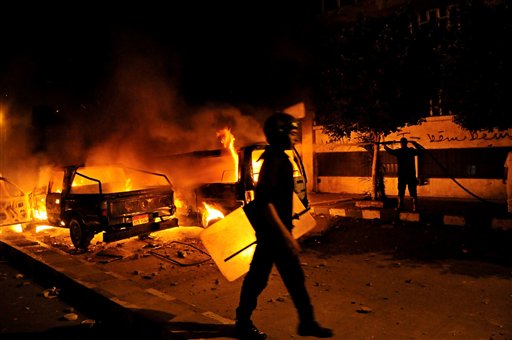 A riot policeman passes a burning vehicle during clashes outside the U.S. Embassy in Cairo, Egypt, early Thursday, as part of widespread anger across the Muslim world about a film ridiculing Islam's Prophet Muhammad.