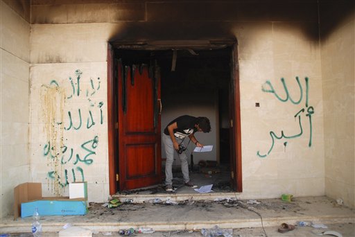 A man looks at documents at the U.S. consulate in Benghazi, Libya, on Wednesday after an attack that killed four Americans, including Ambassador Chris Stevens. The graffiti reads, "no God but God," "God is great," and "Muhammad is the Prophet."
