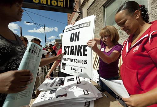 Members of the Chicago Teachers Union distribute strike signs at the union's strike headquarters in Chicago on Saturday. The union announced Sunday night that its 25,000 members will go on strike Monday morning for the first time in 25 years after contract talks with the school district failed. Chicago;USA