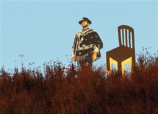 A life-sized cardboard cutout of actor Clint Eastwood next to an empty chair is seen overlooking a freeway in Glendale, Calif., on Tuesday.
