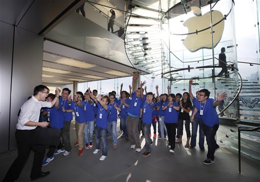 A customer cheers with staff members as the Apple store in Hong Kong started selling iPhone 5 on Friday. Apple's Asian fans jammed the tech juggernaut's shops in Australia, Hong Kong, Japan and Singapore to pick up the latest version of its iPhone.