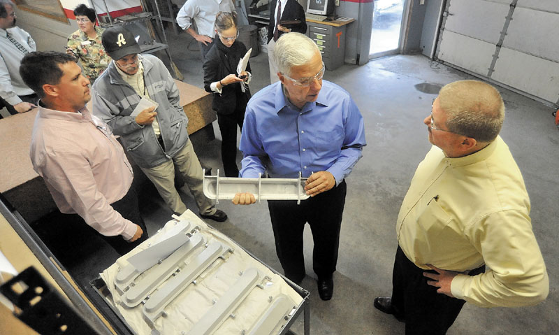 U.S. Rep. Mike Michaud, center, holds a B&B Precise Products fabricated control panel designed for the Boeing 787 Dreamliner with B&B Precise Products owner Will Rood, right and general manager Kevin Wood, far left, during a tour of B&B Precise Products on Neck Road in Clinton on Wednesday.