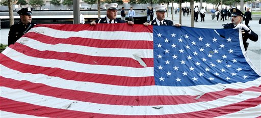 Police officers of the Port Authority of New York and New Jersey, carry an American flag that flew over at the World Trade Center towers, during the 11th anniversary ceremonies at the site of the World Trade Center, in New York, Tuesday Sept. 11, 2012. The Associated Press photo