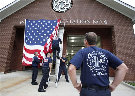 Capt. Kris Small of the Rock Hill, S.C., Fire Department watches as other firefighters put a giant American Flag on the front of Station 4 on Tuesday to commemorate Sept. 11 terrorist attacks.