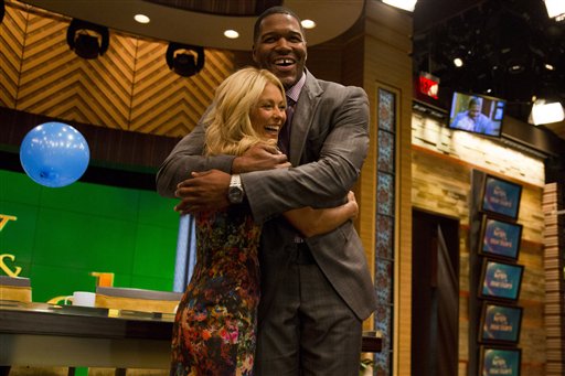 Former football player Michael Strahan, right, embraces Kelly Ripa on the set of the newly named "Live! with Kelly and Michael" on Tuesday in New York.