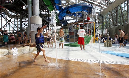 In this Aug. 8, 2012 photo, a youngster plays in the water spouts at the Jay Peak Pump House indoor waterpark in Jay, Vt. Guests at Northern New England ski resorts are still enjoying waterparks and zip lines, but after a dismal, snowless winter, owners are looking ahead and trying to lock in skiers to season passes for the coming season. (AP Photo/Toby Talbot)