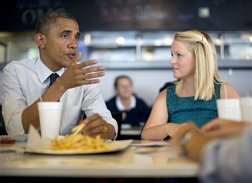 President Barack Obama visits with Emily Young, first-time voter and student and University of Miami, at OMG Burger on Thursday, Sept. 20, 2012, in Miami, Fla. (AP Photo/Carolyn Kaster)