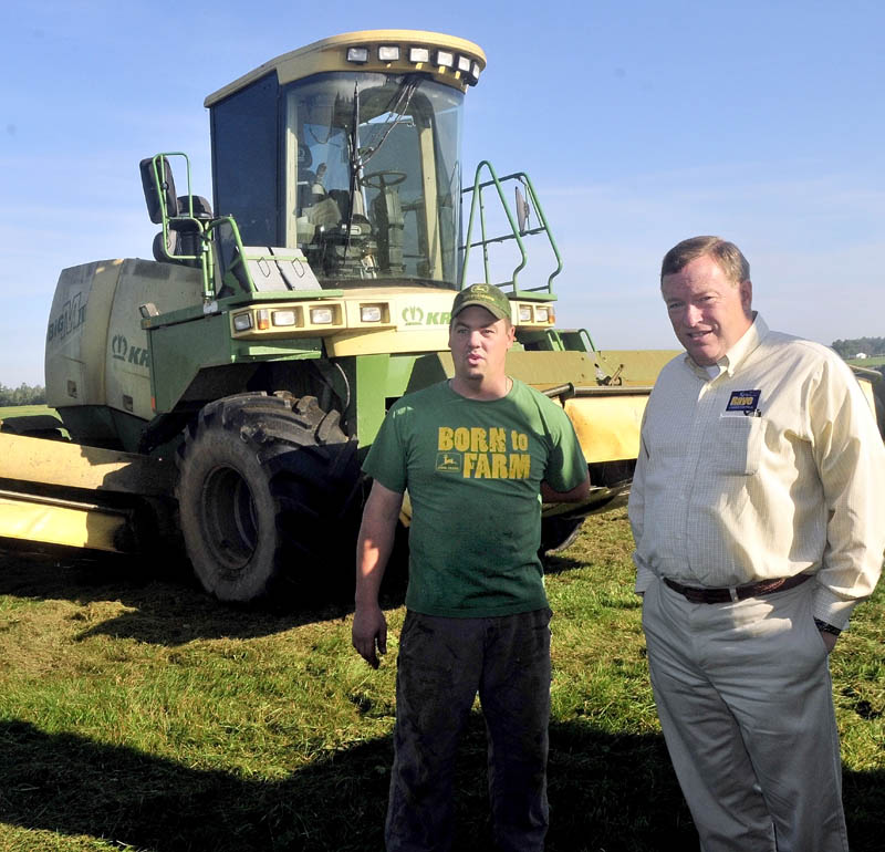 FARM TOUR: Second District Congressional candidate Kevin Raye, right, and Flood Brothers farm employee Jake Owens look over a hay field that was being mowed in Clinton during a campaign stop on Thursday.