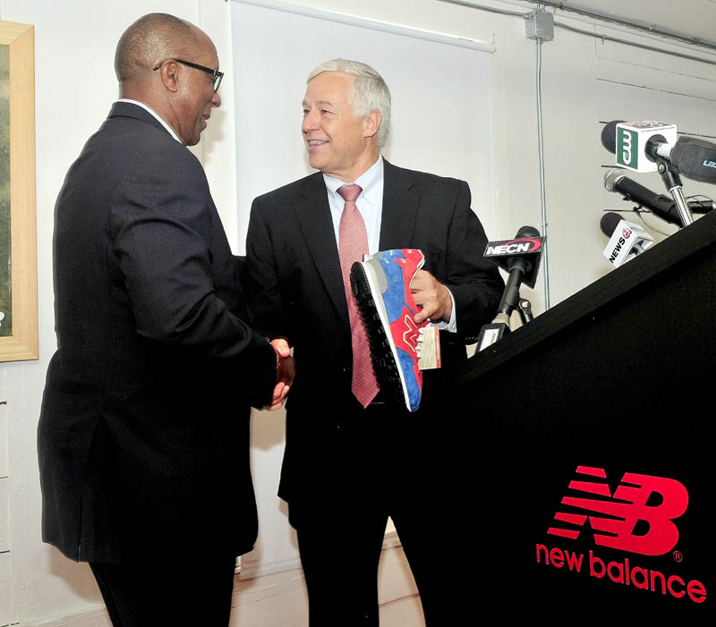 RUNNING: U.S. Rep. Mike Michaud, right, gives U.S. Trade Representative Ambassador Ron Kirk a pair of New Balance shoe company sneakers on behalf of the company during a tour of the facility in Norridgewock on Thursday.