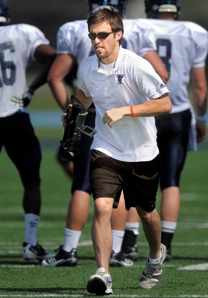 Jimmy Bump, a former quarterback for Cape Elizabeth and now a senior at UMaine, jogs downfield while filming a recent Black Bears practice at Morse Field in Orono.