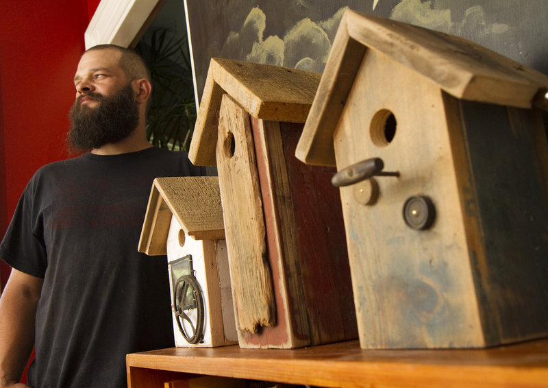 Reuben J. Little with some of the birdhouses he creates in his Portland workshop. He often finds old wood and other materials from doing carpentry jobs.