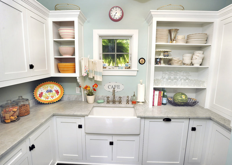 Christine Laughlin’s kitchen, top, was included on this year’s tour because it’s a good example of the all-white style that’s popular now. Angela Meyer’s kitchen, below, combines granite counter tops and other custom-made materials with modestly priced IKEA cabinetry.