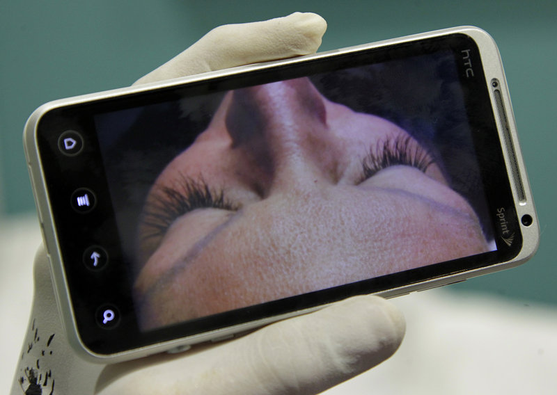 Technician Tray Marotta displays her eyelash extension on her phone for clients at Dr. Patty’s Dental Boutique.