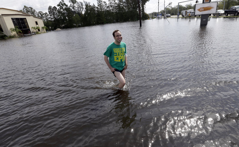 Christopher Keller walks through floodwater Saturday in Reserve, La. More than 400,000 customers remained without electricity in the state in the aftermath of Isaac.