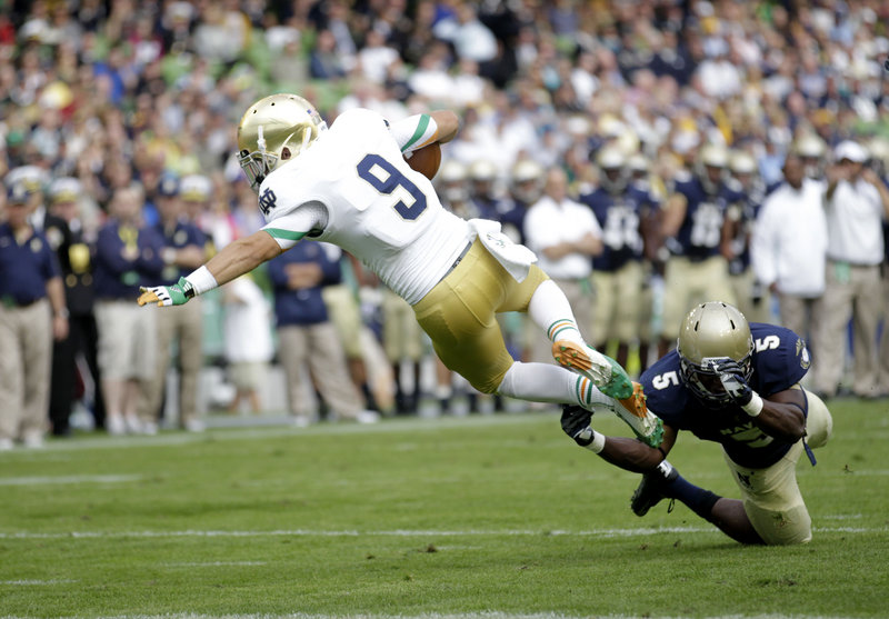 Notre Dame’s Robby Toma lunges for the end zone as Navy’s Quincy Adams arrives too late to keep him from scoring a touchdown Saturday in Dublin, Ireland. Notre Dame won, 50-10.