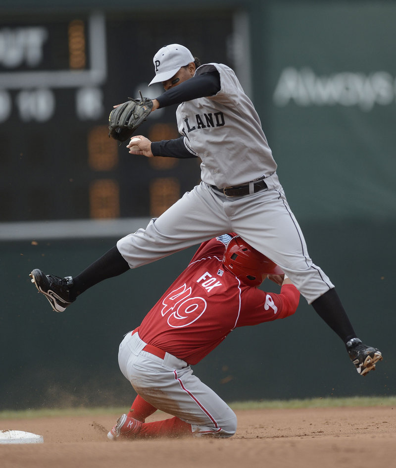 Jake Fox of the Reading Phillies disrupts Sea Dogs shortstop Xander Bogaerts’ attempt to turn a double play.