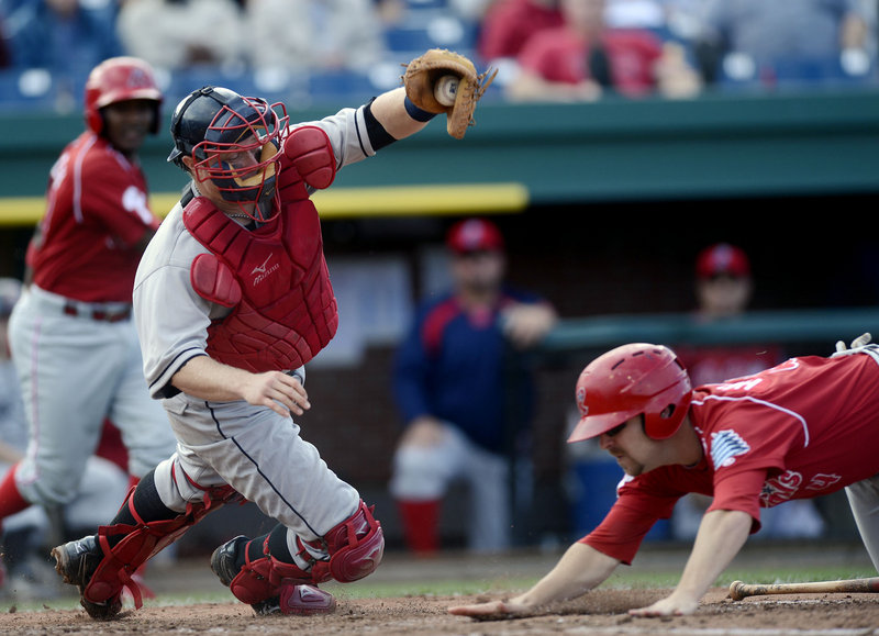 Tag Hulett of the Reading Phillies dives for the plate and beats the tag by Sea Dogs catcher Matt Spring to score a run in the fifth inning Sunday. The Phillies moved closer to clinching an Eastern League playoff berth with a 5-0 win.