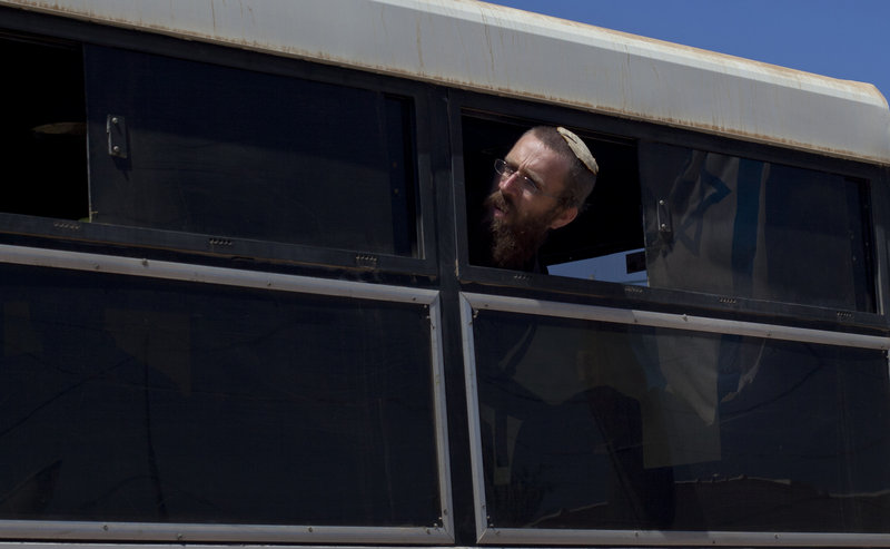 A Jewish settler looks out of a bus window after being evacuated from Migron on Sunday. Migron residents eventually will be relocated to homes a mile from their original site.