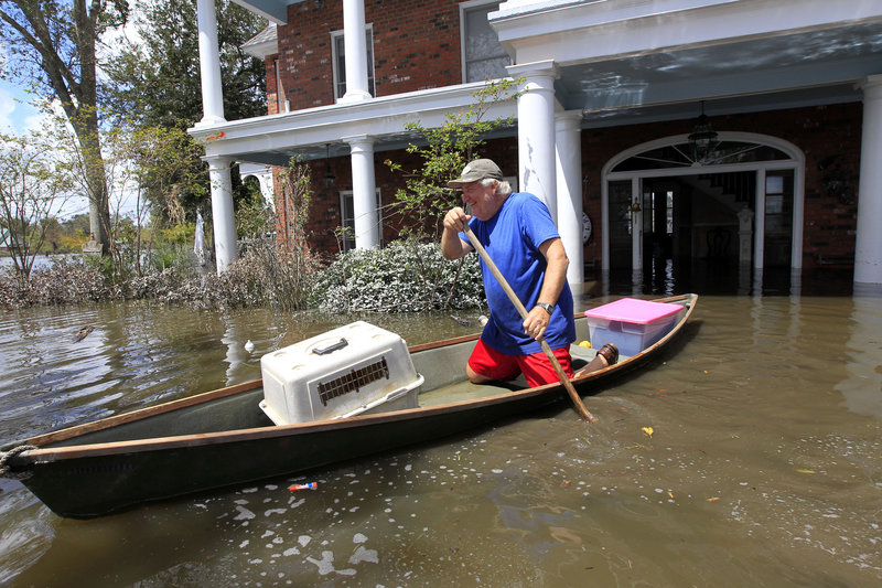 Don Duplantier paddles a pirogue from his flooded home as floodwaters from Hurricane Isaac recede in Braithwaite, La., on Sunday. Duplantier had retrieved his cat and his daughter’s bridesmaid dress for his son’s upcoming wedding.
