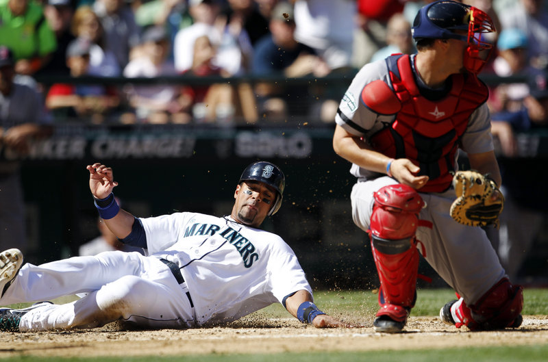 Franklin Gutierrez of the Mariners slides safely into home behind Red Sox catcher Ryan Lavarnway, part of a four-run rally in the fourth inning that gave Seattle a 4-1 victory.