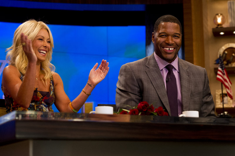 Former New York Giant Michael Strahan sits with his co-host Kelly Ripa on the set of the newly named “Live! with kelly and michael” on Tuesday in New York.