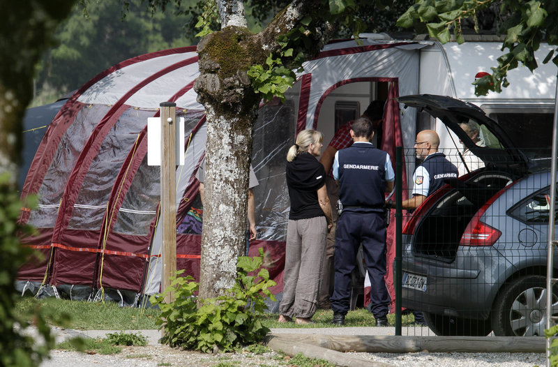 Investigators stand at the campsite where several people were methodically killed. French officials are finding international links tying the slain family to Britain, Iraq and Sweden.