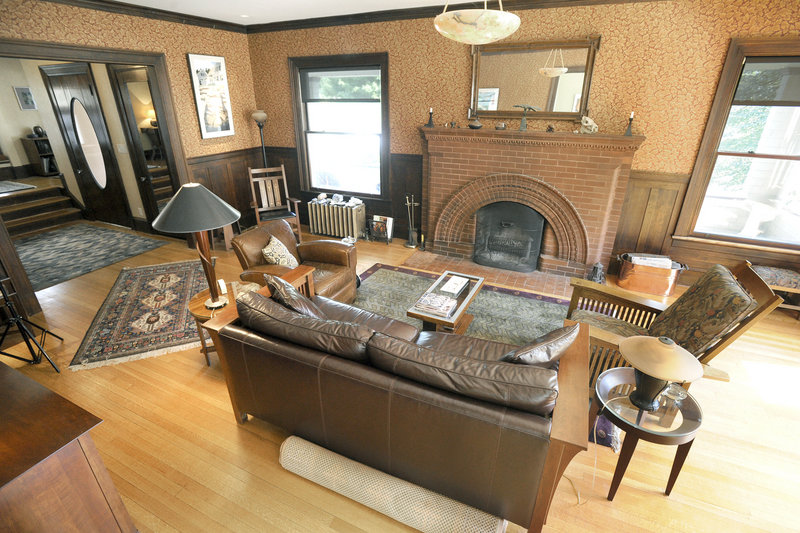 The living room, with its reproduction wallpaper, wainscoting and one-of-a-kind fireplace