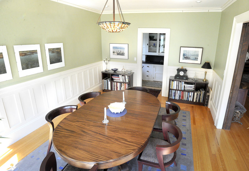 The bright dining room, with wood floors and white wainscoting